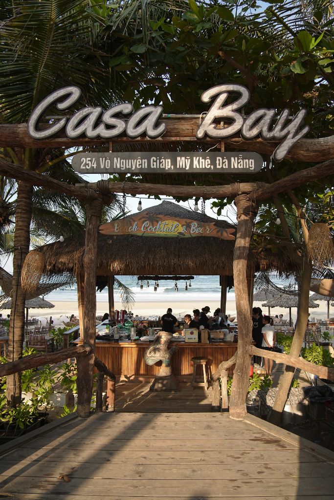 Casa Bay Beach Club wooden entrance arch with ocean view behind