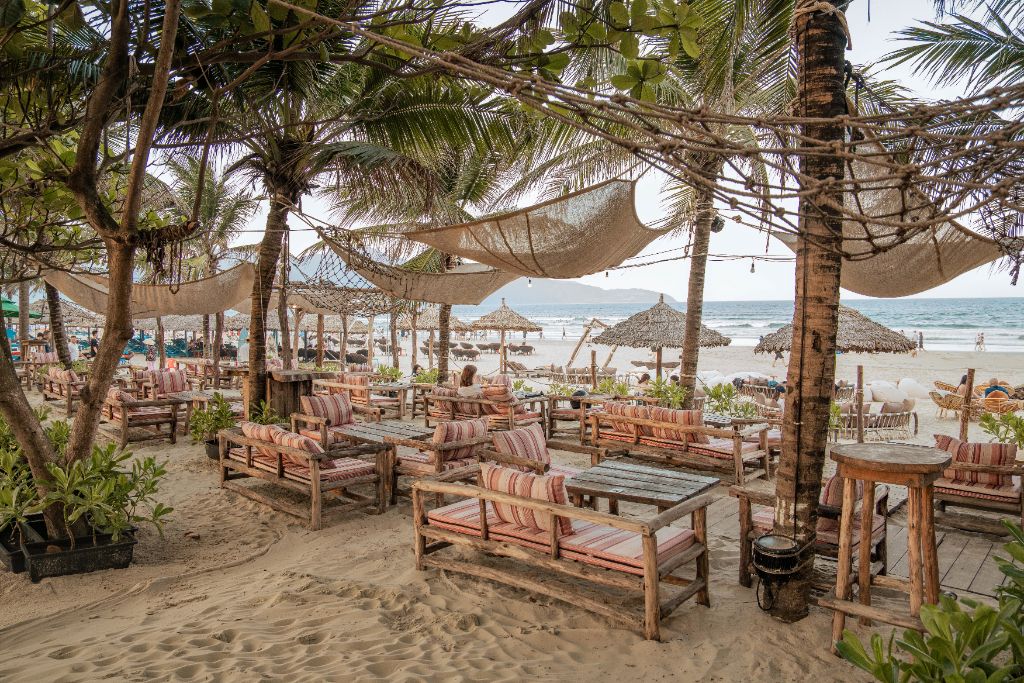 Tropical beachside lounge with wooden sofas and ocean view