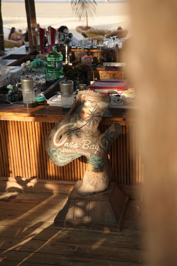 Wooden Casa Bay tree sculpture at the bar counter with beach view